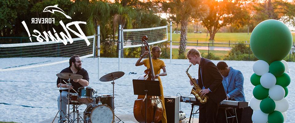 Photo of a band playing on a voleyball sand field.