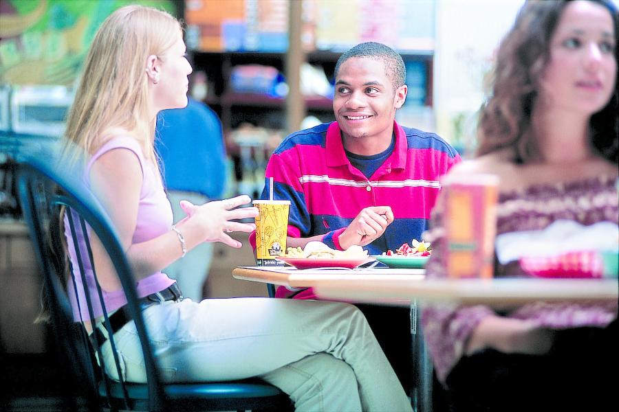 Students seating at a cafeteria table.